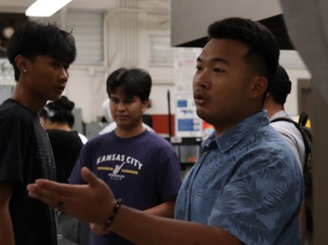 Ethan Momohara surrounded by students as he explains a concept.