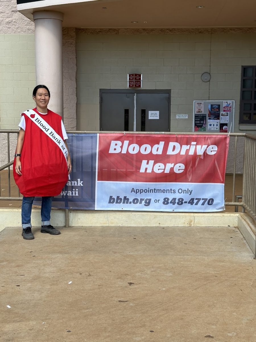 Cindy Lum, in a blood drop costume, encourages Sabers to sign-up to give blood.